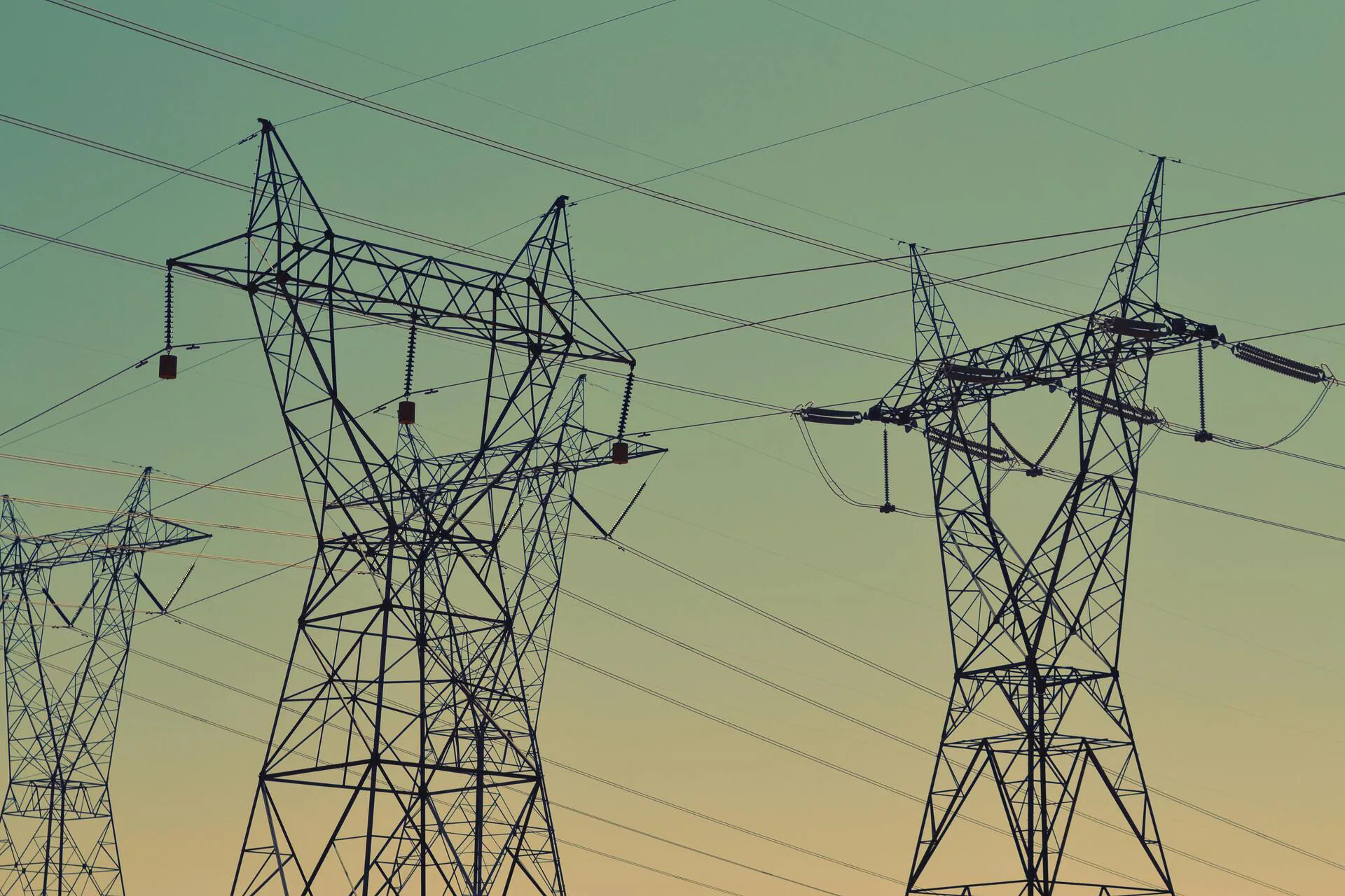 Electricity transmission pylons at sunset, supplying commercial energy