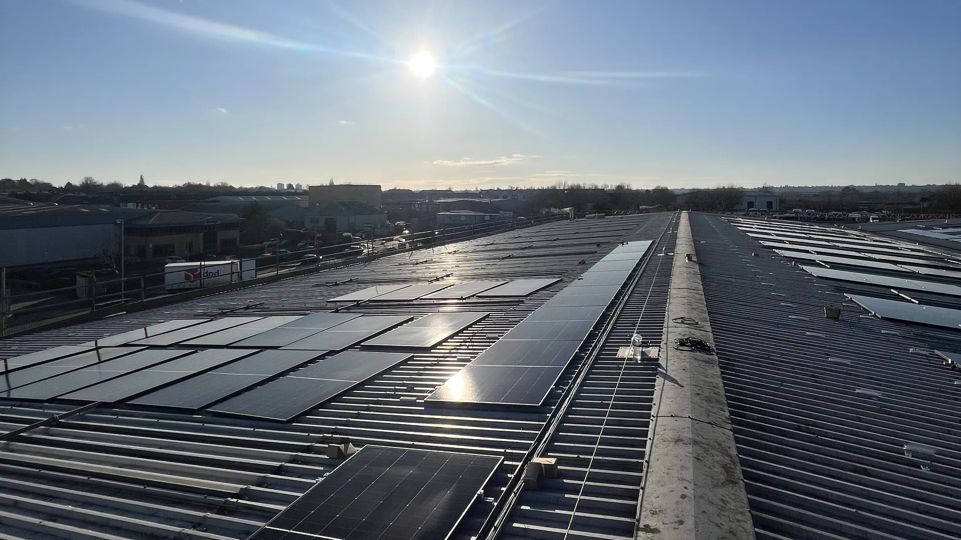 Commercial solar PV panels installed across a warehouse rooftop on a sunny day